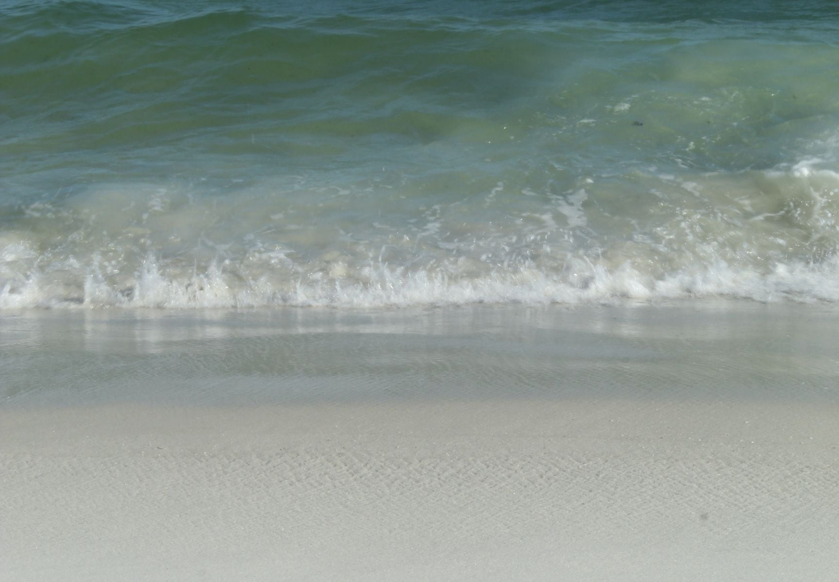 White quartz sand and calm turquoise water on a Florida Gulf Coast beach at midday