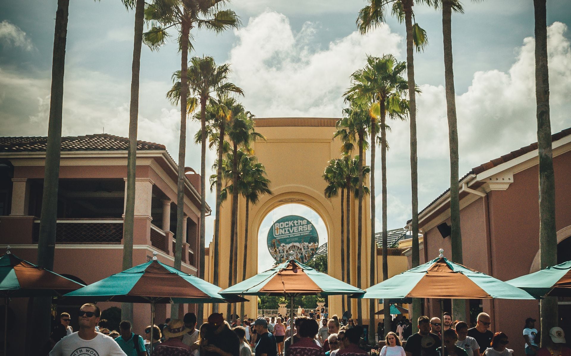 Orlando theme park entrance with palm trees under a bright sky