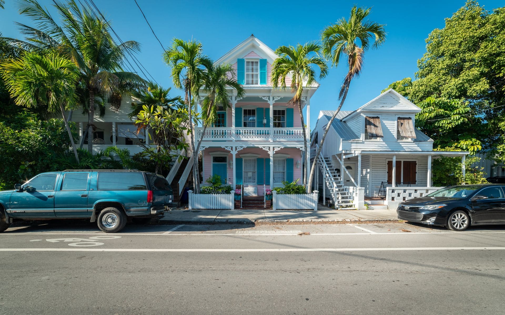 Colorful conch houses and palm trees on a quiet Key West street in morning light